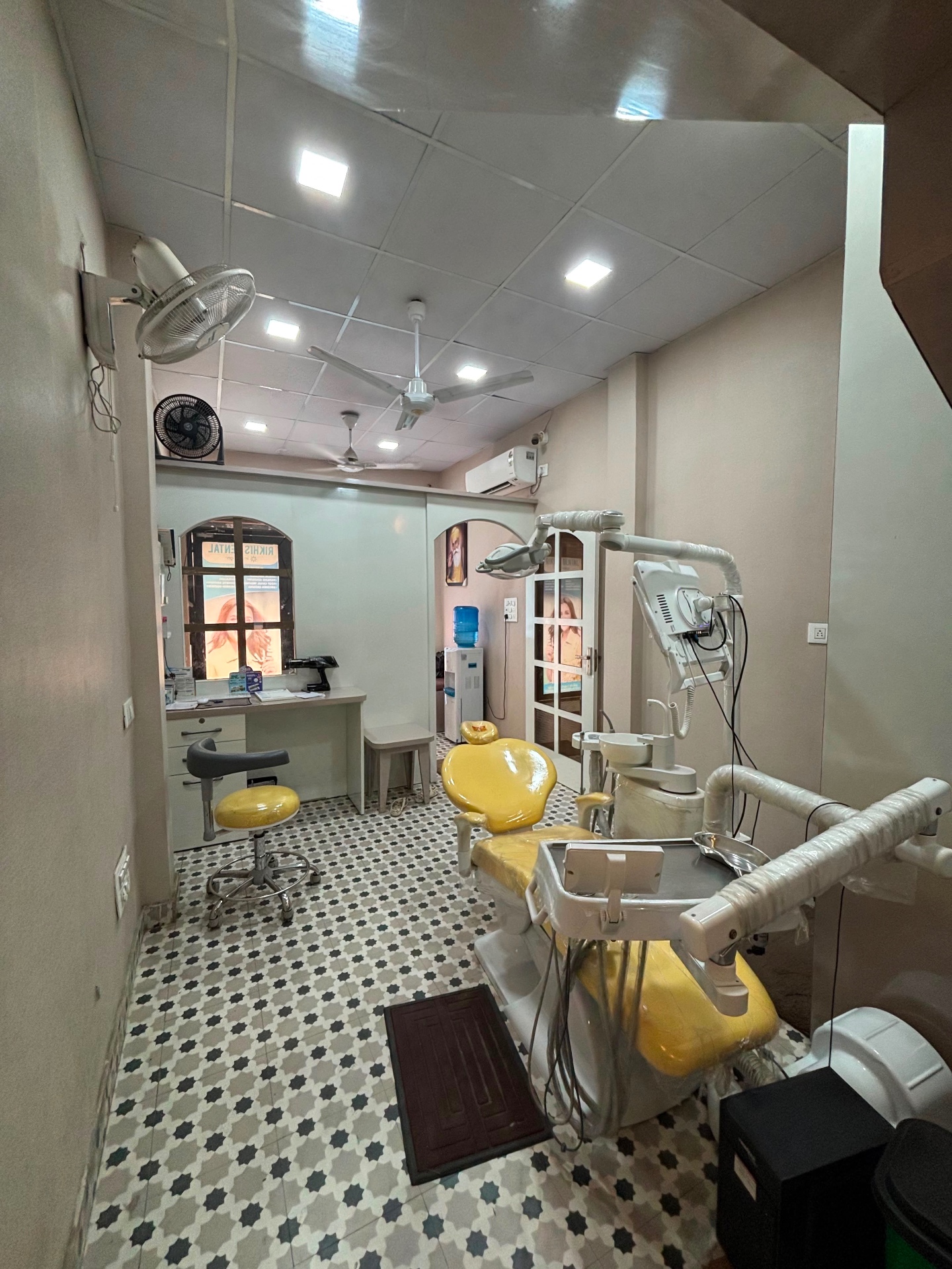 Dental treatment room with yellow chair and modern equipment