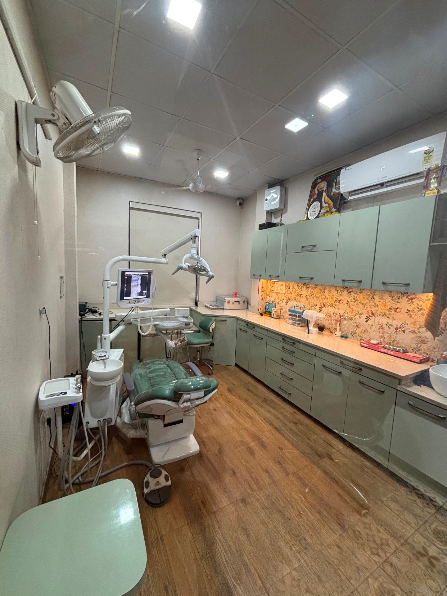 Modern green dental treatment room with digital imaging equipment